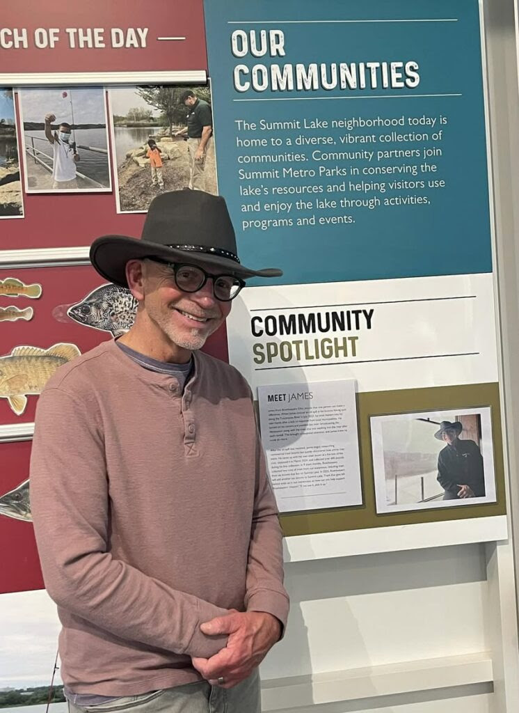 James Carnahan standing by Our Communities poster